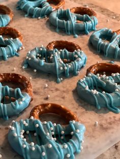 blue frosted pretzels with sprinkles on a marble counter top