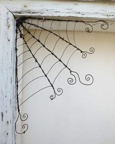 a spider web is hanging from the side of an old white door with peeling paint