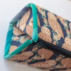 a close up of a bag with a green ribbon on the bottom and an image of pineapples printed on it