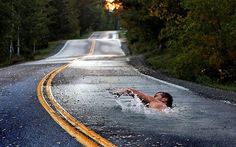 a person swimming in the middle of a road