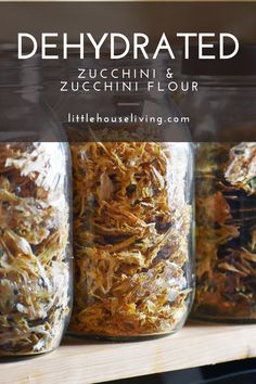 three jars filled with dried herbs on top of a wooden shelf in front of the words dehydrated zucchini and zucchini flour