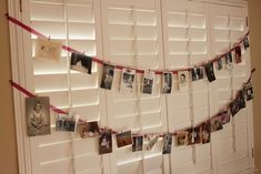 a wall with pictures hanging on it and some red ribbon in front of the door