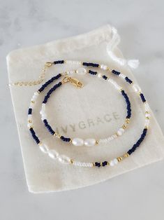 Delicate beaded necklace made with a mixture of freshwater pearls, navy blue, gold and white glass seed beads and delicate crystal beads.   The necklace fastens with an 18ct gold plated sterling silver lobster clasp and an extension chain which allows a length between 41-44cm.  The extension chain is finished with a tiny freshwater pearl. Each item I make is unique and will differ very slightly in colour/shape due to the nature of the gemstones.  My jewellery is strung on high quality, flexible