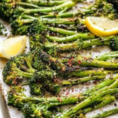 asparagus and lemon on a baking sheet with seasoning