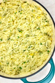 a blue pan filled with rice and vegetables