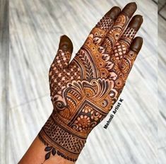 a hand with henna on it that is showing the intricate pattern and design,