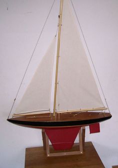 a model sailboat sitting on top of a wooden stand