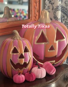 two carved pumpkins sitting on top of a table next to each other with the words totally tika written above them