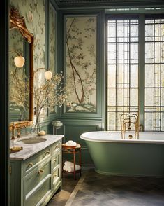 a bath room with a tub a sink and a mirror on the wall next to a window