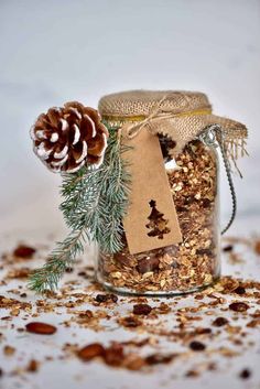 a jar filled with granola next to a pine cone