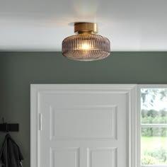 a light that is hanging from the ceiling in a room with green walls and white doors