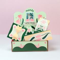 a box with some cards inside of it on a table next to a pink wall