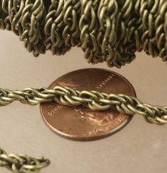 a penny sitting on top of a table next to chains