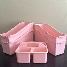 three pink plastic containers sitting on top of a table