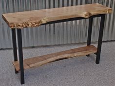 a wooden table sitting on top of a carpeted floor next to a metal wall