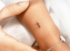 a woman's arm with a small spider tattoo on the left side of her arm