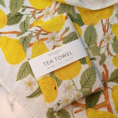 a tea towel with lemons on it and a tag hanging from the top of it