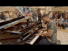 a man sitting at a piano in front of a crowd