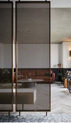 a living room filled with lots of furniture and walls covered in metal mesh panels,