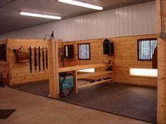 the inside of a horse barn with stalls and tacks on the walls, windows, and doors