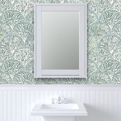 a white sink sitting under a bathroom mirror next to a wall mounted faucet