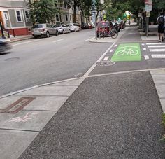 a bike lane painted green on the side of a street