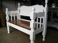 a white wooden bench sitting on top of a hard wood floor