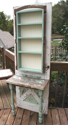 an old bookcase is sitting on a wooden deck