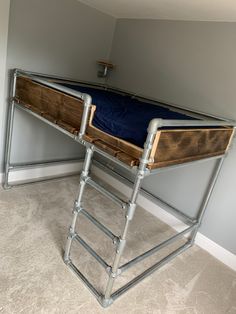 there is a bunk bed with metal bars on the bottom and blue sheets on top