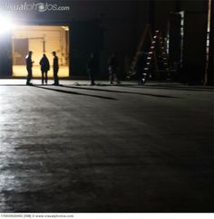 several people standing in an empty warehouse at night