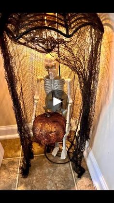 a skeleton sitting in a chair made out of fishing nets and branches, with the caption's video below it