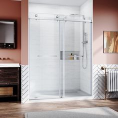 a bathroom with a walk in shower next to a white sink and wooden flooring