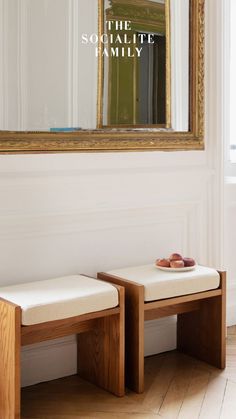 two wooden benches sitting in front of a mirror on the wall next to each other