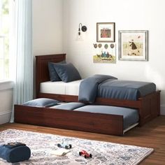 a bed sitting on top of a wooden floor next to a window