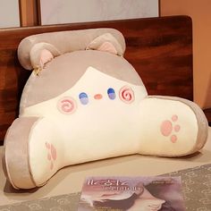 a teddy bear shaped pillow sitting on top of a table next to a magazine cover