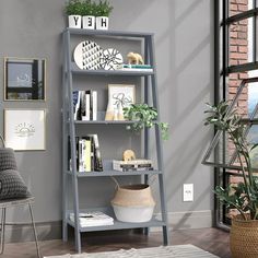 a living room with a gray bookcase next to a chair and potted plant