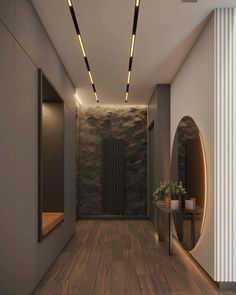 an empty hallway with wooden floors and lights on the ceiling, along with a round table