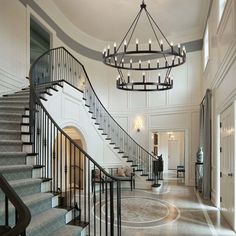 an elegant foyer with chandelier and staircase leading up to the second floor area