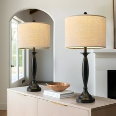 two lamps sitting on top of a wooden table