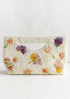 A white beaded east-west clutch with cutout handle and pastel floral pattern. Dried Flower Beads, Beaded Clutch, White Backdrop, Dried Floral, Beaded Purses, Small Pouches, Beaded Bags, Canvas Pouch, Butterfly Design