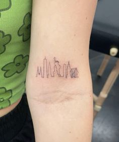 a small city skyline tattoo on the arm