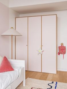 a bedroom with pink walls and white furniture