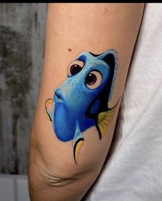 a woman's arm with a blue fish tattoo on it