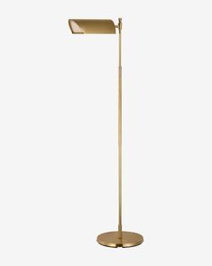 a gold floor lamp with a white background