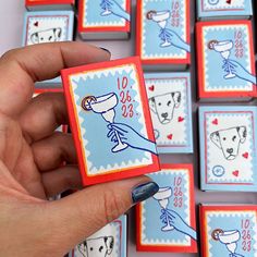 a hand holding a small card with pictures of dogs on it in front of other cards