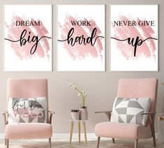 two pink chairs in front of a wall with black and white prints on it that says dream, work, never give up