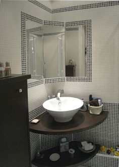 a white sink sitting on top of a wooden shelf in a bathroom next to a mirror