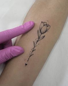 a woman's arm with a flower tattoo on it