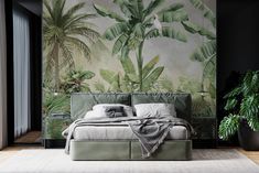 a bedroom with a bed, plant and wall mural in the background that has palm trees on it