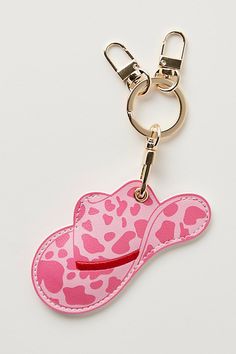 a pink cowgirl hat shaped keychain on a white surface with a metal hook